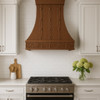 designer copper range hood with a Gothic apron featured in a transitional style kitchen blending modern lines with warm rustic materials