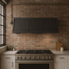 Minimalist zinc range hood with straps in an industrial loft style kitchen featuring concrete surfaces, black steel accents, and open shelving