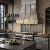 Loft style steel range hood with riveted straps in a large instrustrial style residentail kitchen
