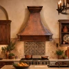 Designer copper range hood in a Spanish kitchen with plaster walls and artisan tile