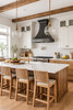 Rustic European style kitchen with a dark hammered zinc range hood with tiered crown and tapered canopy