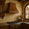 Old world copper vent hood in traditional European kitchen, smooth aged copper canopy above classic cabinetry, stone backsplash and timeless architectural details
