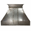 Riveted raw iron range hood with industrial patina, bold architectural form and reinforced metal detailing