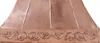 Polished copper range hood with Rococo apron design detail view, ornate scrollwork band with reflective hammered copper surface
