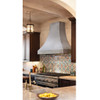 Smooth zinc range hood with natural finish installed in a Spanish Revival style kitchen