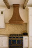 Custom-made wall-mounted copper range hood in a Parisian-style kitchen