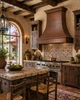 Hand-hammered bell copper range hood with architectural apron in Hacienda kitchen with terracotta and rustic timber