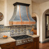 Polished zinc range hood with copper straps and apron in a transitional kitchen with a Mexican flavour