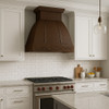 Transitional kitchen with a recirculating hand-hammered copper range hood
