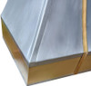 Custom zinc and brass metal range hood close up of apron detail, brass band with rivets contrasting smooth zinc panels