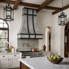 Spanish colonial style kitchen furnished with a brushed zinc range hood with darkened zinc straps