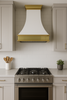 30 inch painted white metal range hood with brass detailing in transitional kitchen, glossy canopy above range with balanced cabinetry