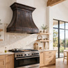 Elevated rustic modern kitchen with octagonal trumpet bell copper range hood in dark coffee patina, light zellige tile and oak floors