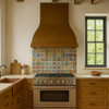 Gently hammered copper range hood in a traditional suburban kitchen with warm patina and flared bell canopy
