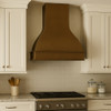 Gently hammered copper range hood front view with bell silhouette and box-style lower trim in transitional kitchen design