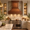 Lightly hammered copper range hood installed in an elegant luxury kitchen with marble details