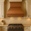 Transitional kitchen with hammered copper range hood, wide trim bands, neutral walls, shaker cabinets, and stone counters