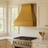 Rustic brass range hood in a suburban kitchen with clean cabinetry and warm lighting