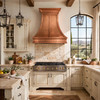 Modern Tuscan kitchen with honey hand-hammered copper hood, cream cabinets, stone backsplash, bright window