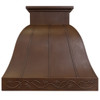Front view of a copper range hood with a floral motif and handcrafted relief details and warm patina tones