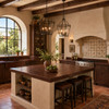 Spanish revival kitchen with a handcrafted hammered copper kitchen countertop and a backsplash