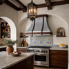 Spanish colonial style kitchen with warm wood cabinetry and reclaimed beams featuring a mixed metal range hood with zinc body and dark copper crown, apron and two vertical straps