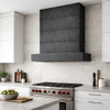 Rectangular zinc range hood with riveted bands in minimalist modern kitchen with flat cabinets and stone backsplash