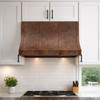Hand-Hammered Copper Range Hood with Adjustable Strap Layout in a bright transitional kitchen with light cabinetry and natural finishes