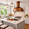 Hammered copper dome range hood with minimal apron in transitional kitchen with white shaker cabinets