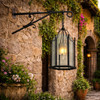 Hand-forged-exterior-wall-lamp-hanging-lantern on historic stucco wall beside arched doorway in Spanish colonial courtyard