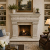 Carved cantera stone fireplace mantel with classical columns in an elegant family room