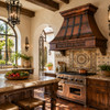 Hammered darkened copper range hood in bright Spanish Revival kitchen with arched openings and handcrafted tile backsplash