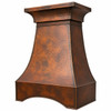 Hammered copper range hood with flared crown and curved apron, angled view