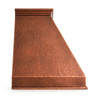 Sloping copper range hood with stepped crown detail showing molded crown trim and hammered copper finish