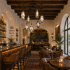 Handcrafted Espejo Viejo ring chandelier above luxury wine bar and tequila lounge with warm artisan atmosphere