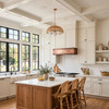 Hammered copper vent hood beneath Shaker cabinets in a modern farmhouse kitchen