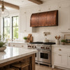 Barrel-vault under-cabinet hammered copper range hood with riveted straps in a modern farmhouse kitchen with white cabinetry