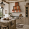 Copper bell range hood with polished zinc straps in a Belgian Farmhouse kitchen with pale oak