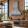 Zinc bell range hood in a bright industrial loft kitchen with exposed brick, steel windows and reclaimed timber