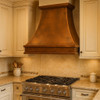 Country style kitchen copper vent hood in traditional kitchen setting, hammered copper canopy above classic cabinetry and tile backsplash