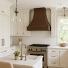 Hammered copper kitchen hood with French Provincial design in transitional kitchen, elegant bell canopy above balanced cabinetry and refined stone surfaces