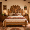 Mexican wooden headboard with hand carved floral vase design in a Southwest bedroom