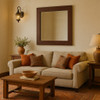 Hammered copper rectangular mirror on a stucco wall in an earth-toned living room with rustic decor
