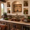 Hammered copper bar sink with rounded square basin in a Hacienda style entertainment space with arched windows