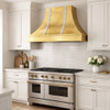 Shiny tin range hood with zinc straps in an elegant transitional kitchen with simple cabinetry