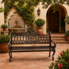 Ornate chocolate aluminum rustic garden bench with victorian scrollwork design in Spanish courtyard