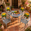 Mexican aluminum dining tables and chairs with colorful village artwork on Southwest patio