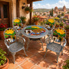 Mexican aluminum dining tables and chairs with colorful village artwork on rustic balcony