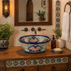 Talavera bath cone shape vessel sink with flowers displayed on bathroom vanity with bright natural light