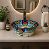 Mexican talavera fish floral round bath sink placed in a modern bathroom with stone countertop and bright space